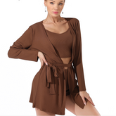 Woman wearing a brown outfit with a matching cardigan on a white background